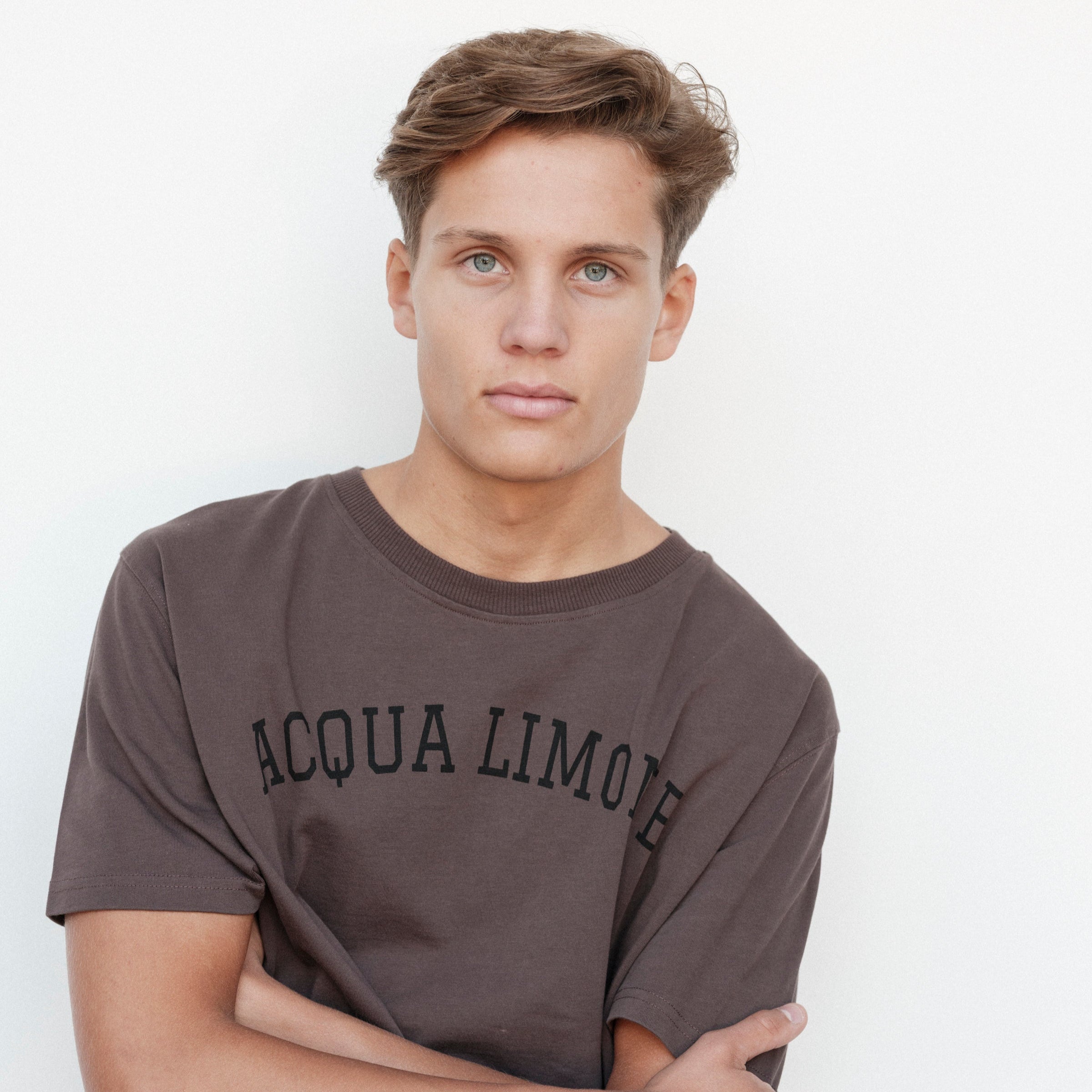 Man wearing a gray 'Acqua Limone' t-shirt against a white background