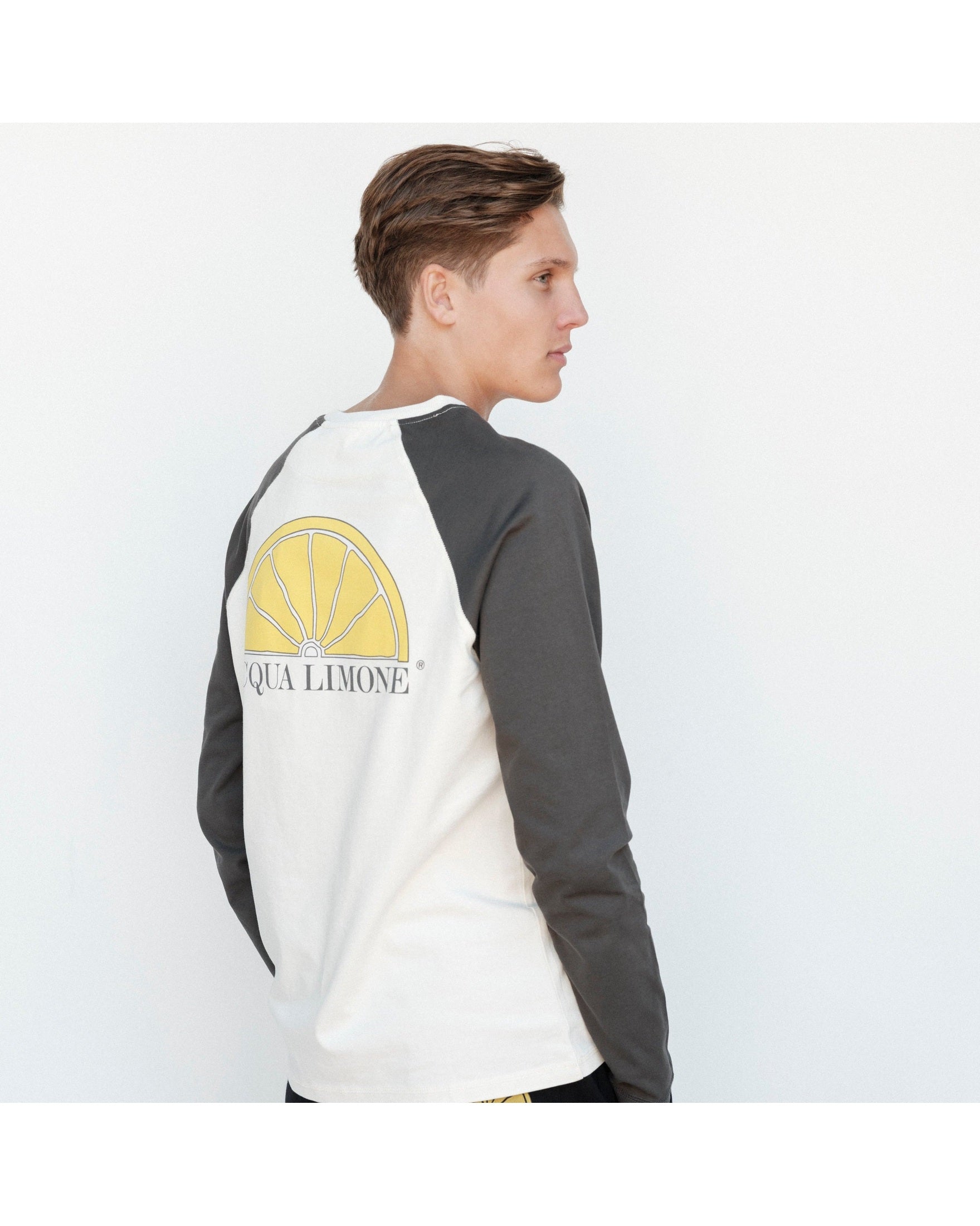 Person wearing a long-sleeve shirt with 'Qua Limone' logo on a white background