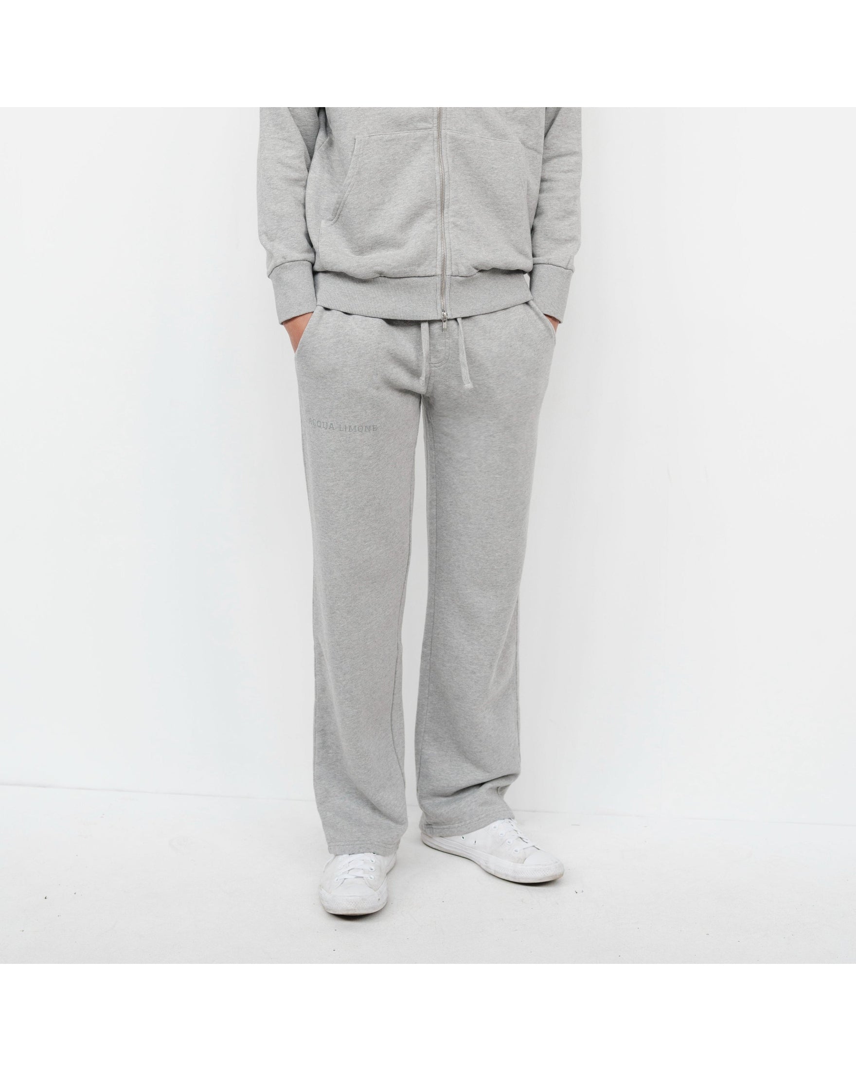 Person wearing a gray tracksuit on a white background