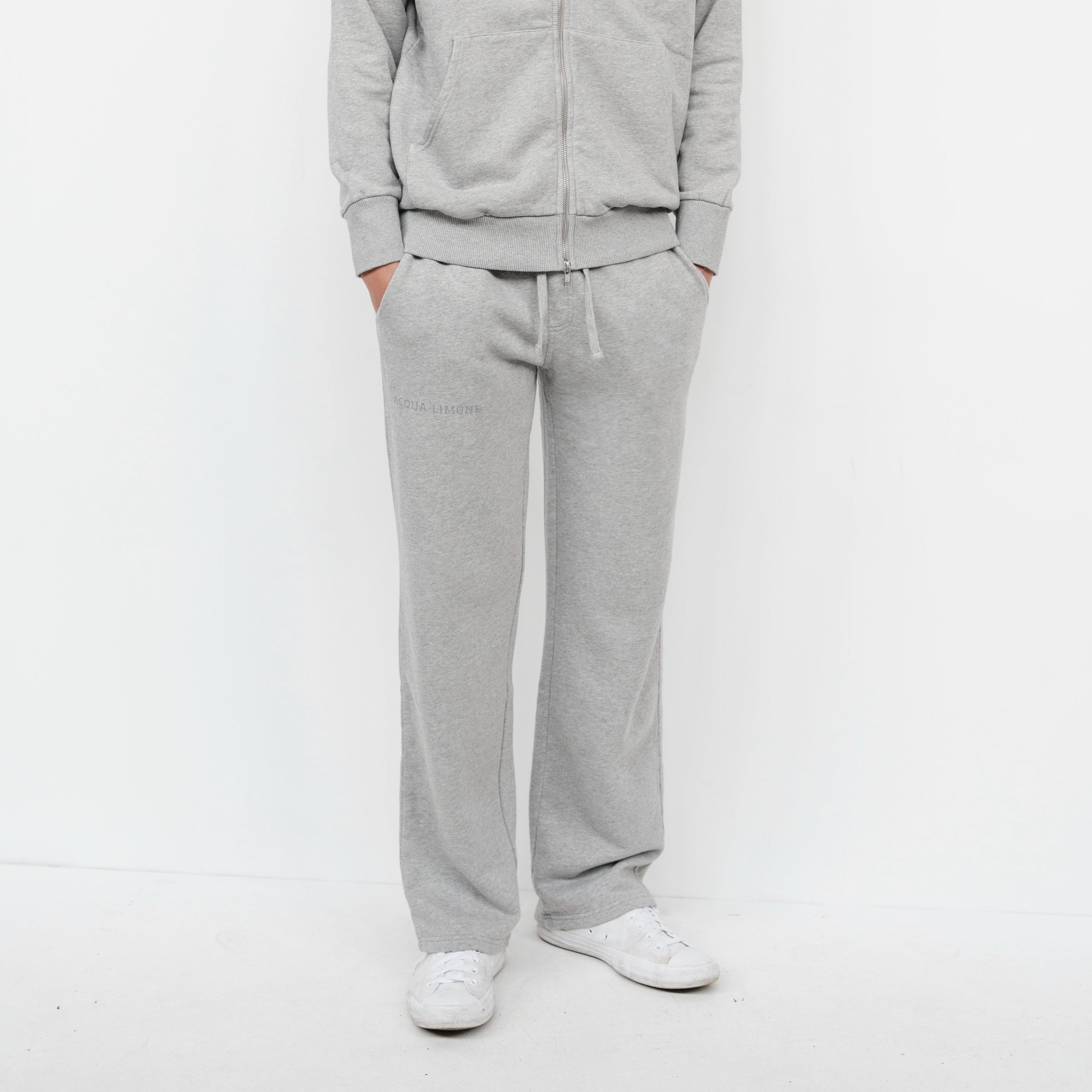 Person wearing a gray tracksuit on a white background