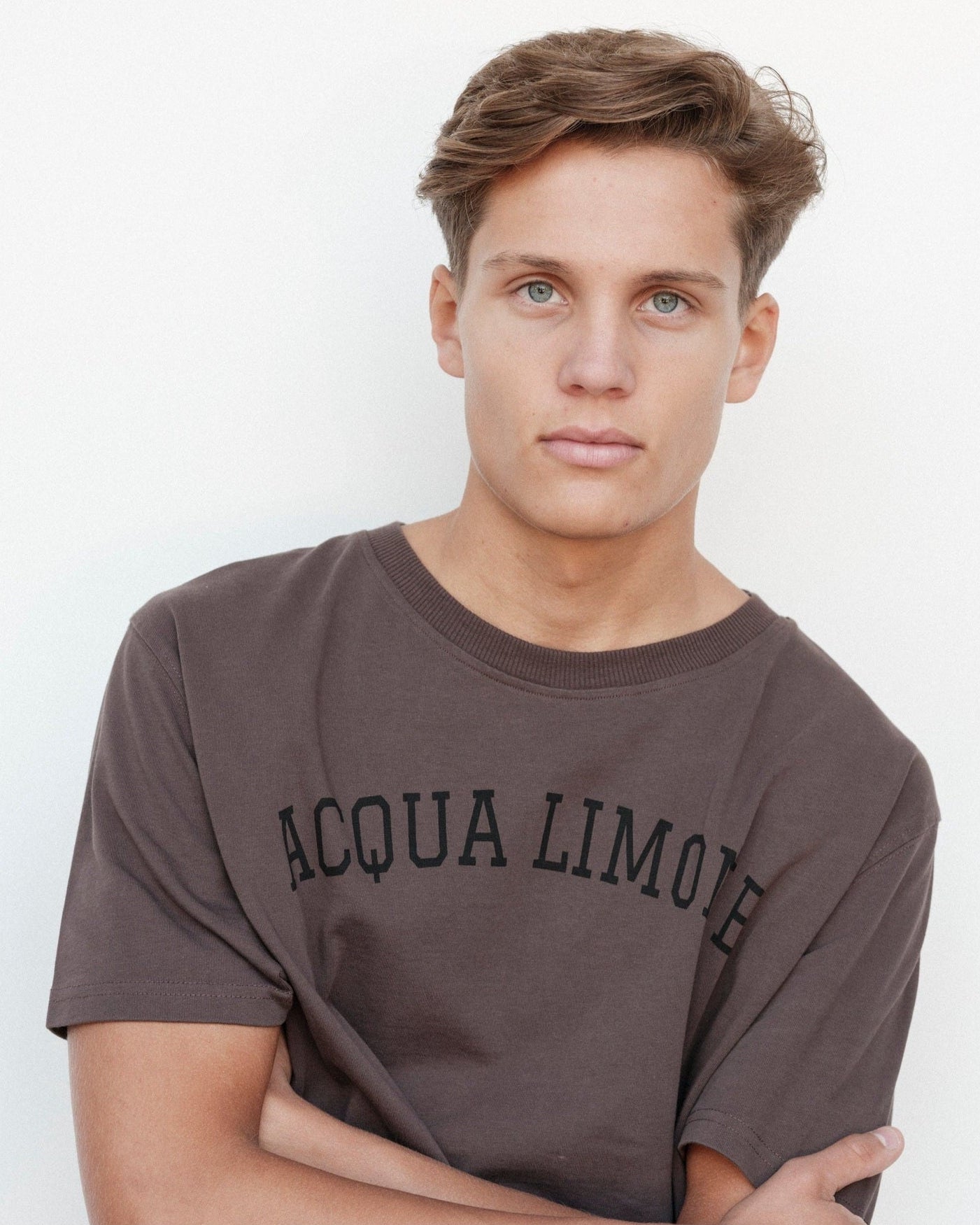 Man wearing a gray 'Acqua Limone' t-shirt against a white background