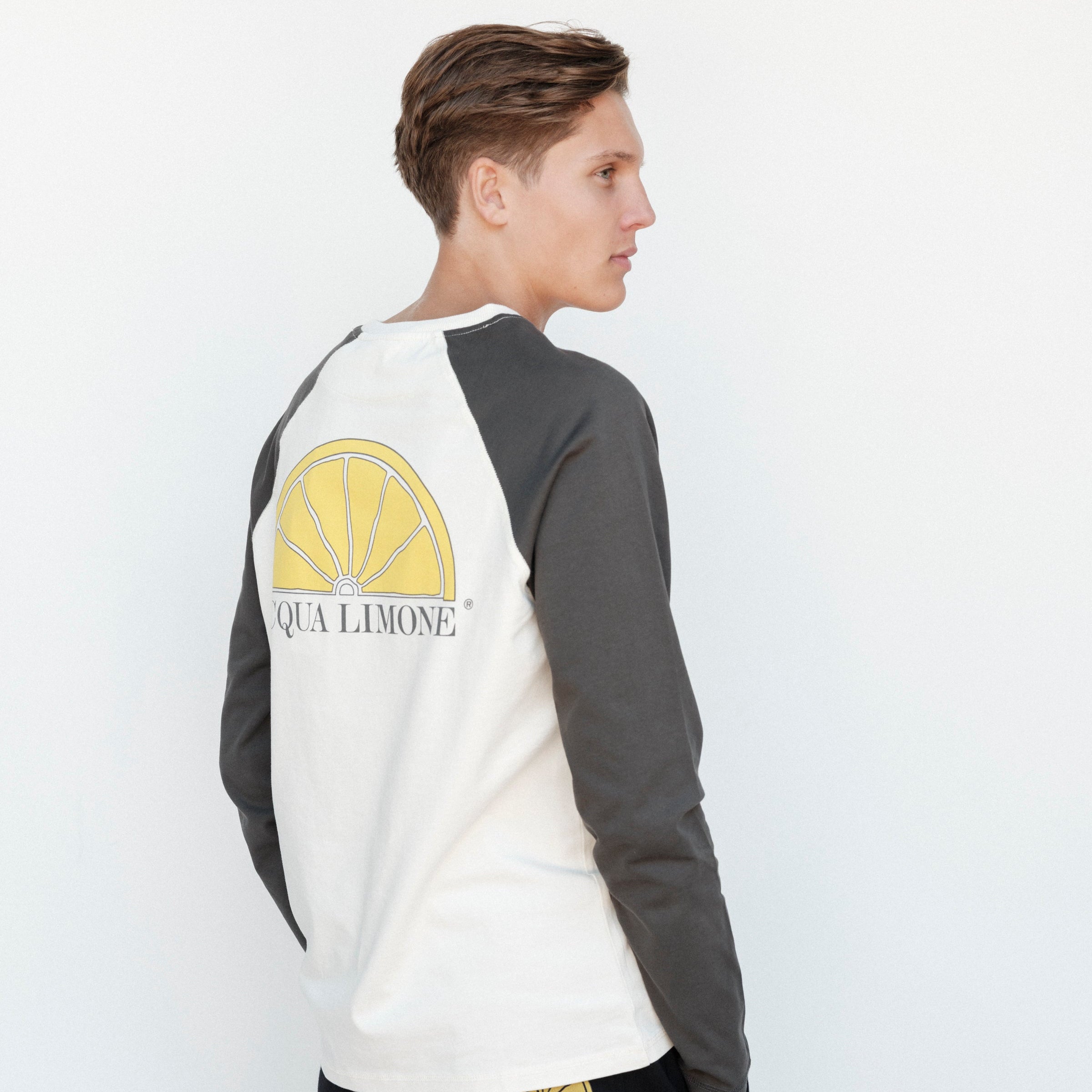 Person wearing a long-sleeve shirt with 'Qua Limone' logo on a white background