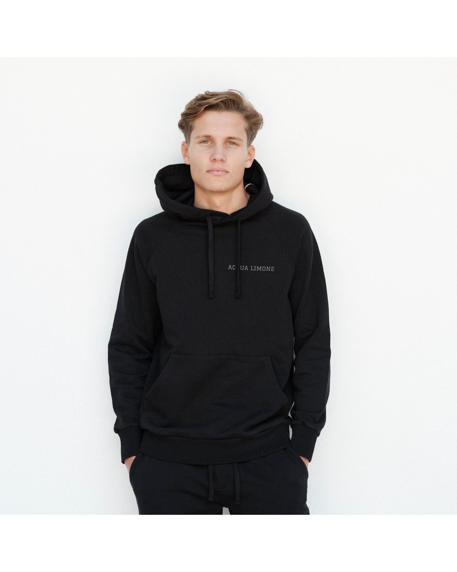 Man wearing a black hoodie with text on a white background