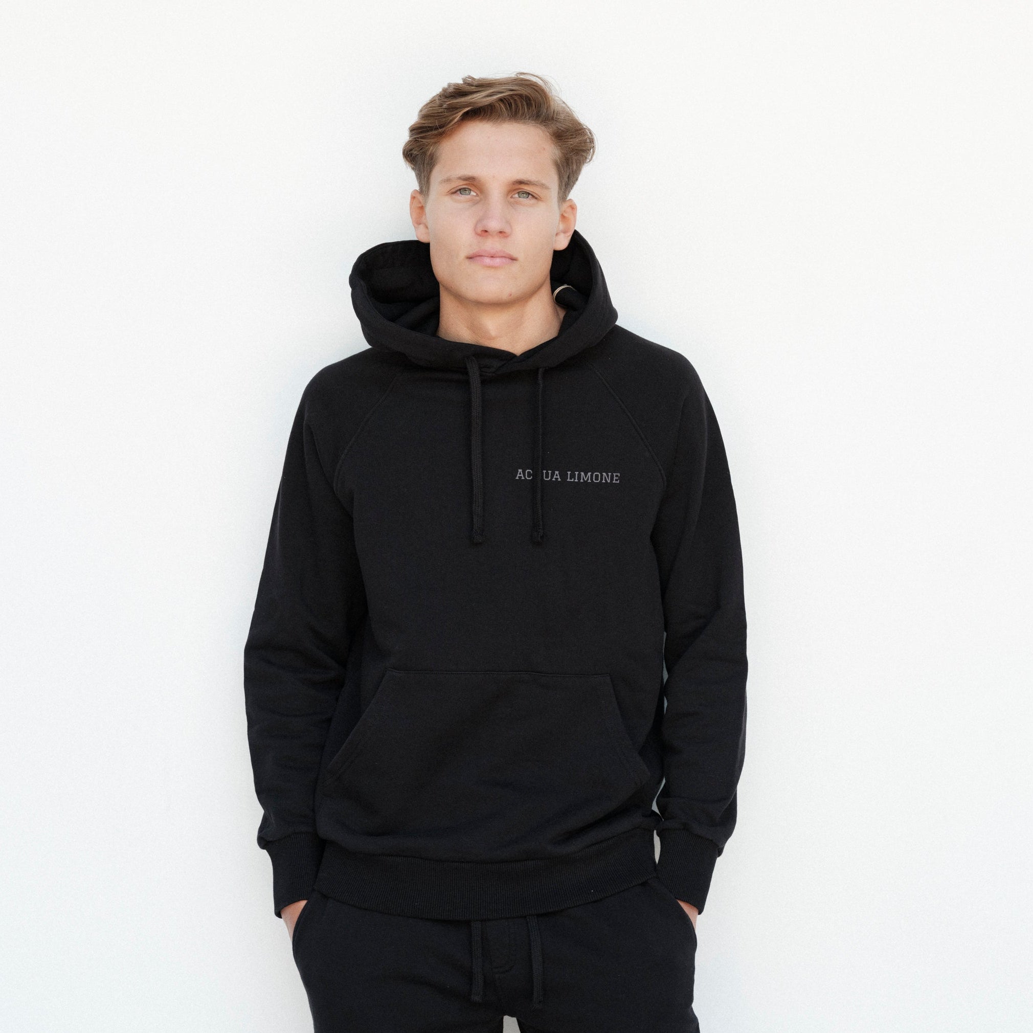 Man wearing a black hoodie with text on a white background