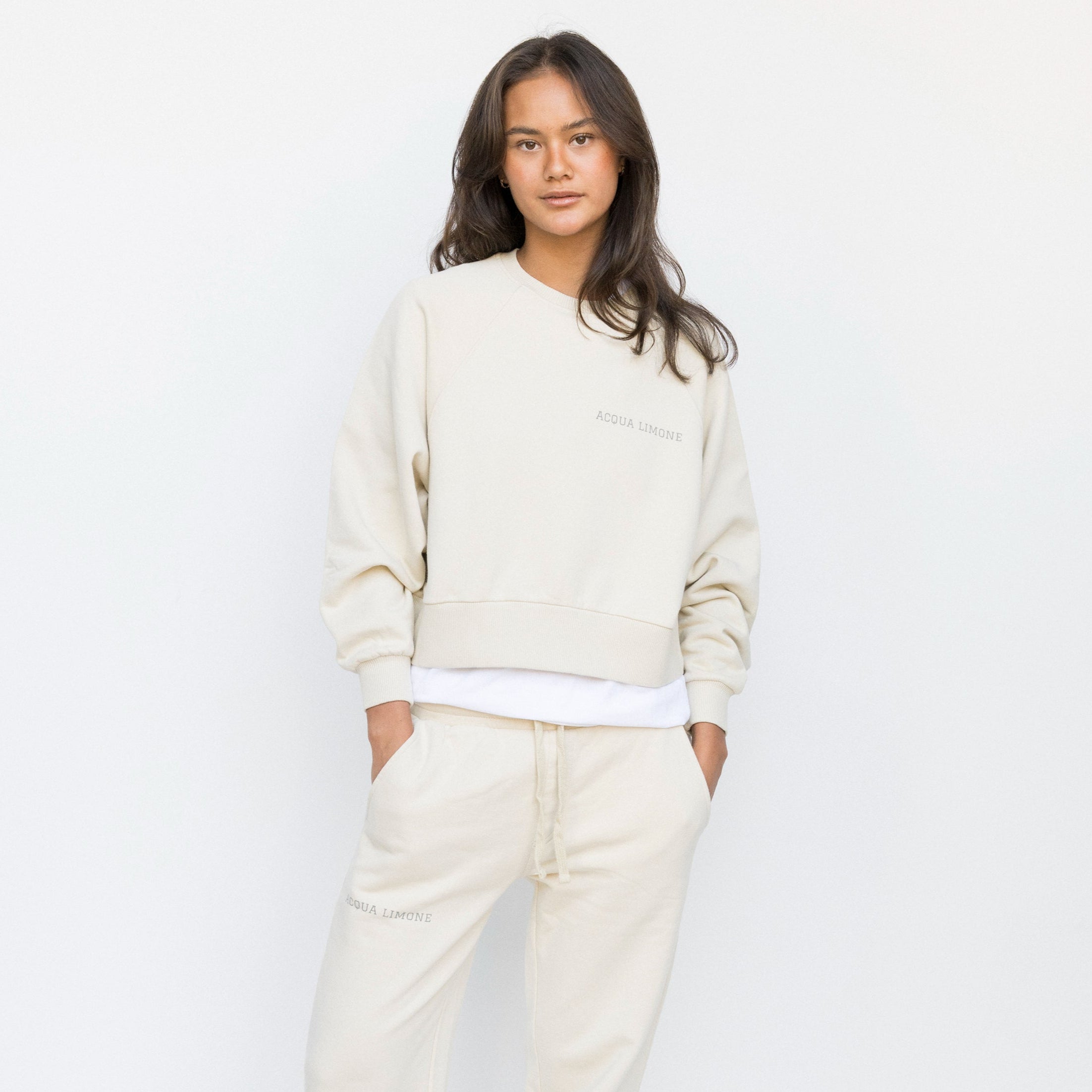 Person wearing a cream-colored outfit against a white background
